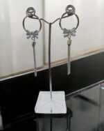 Silver hoop earrings with bow pendant